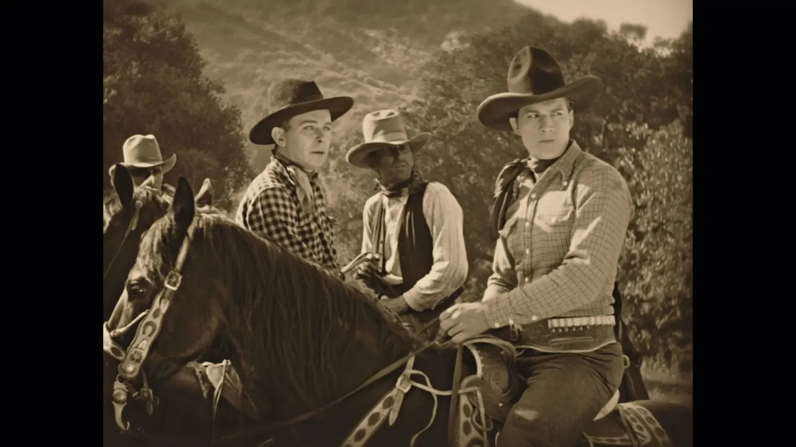 Sepia‑toned still from The Man from Nevada (1929): Tom Tyler in a wide‑brim hat on horseback with three fellow riders, mountains and trees behind—used for Undercrank Productions’ nitrate‑scan Blu‑ray restoration.